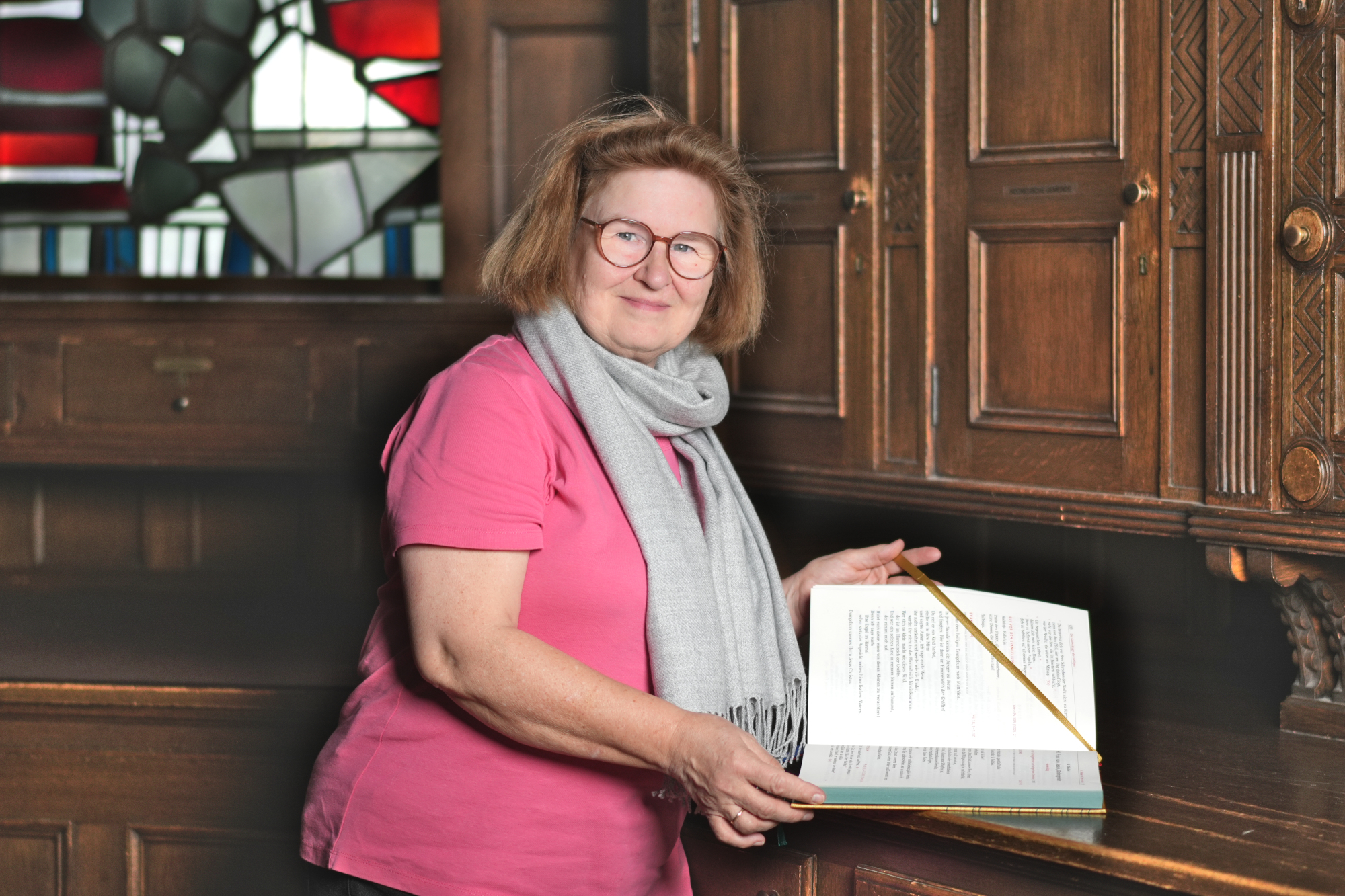 Renate Görtz schlägt ein liturgisches Buch in der Sakristei auf